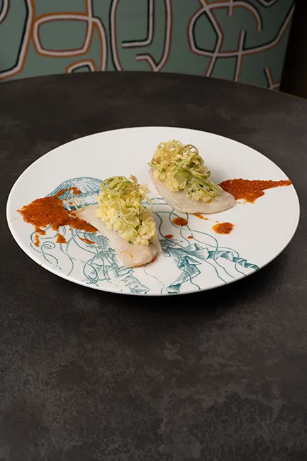 Gallinelle arrosto con patate, porri croccanti e salsa mediterranea impiattate al ristorante di pesce Da Sacerno a Bologna