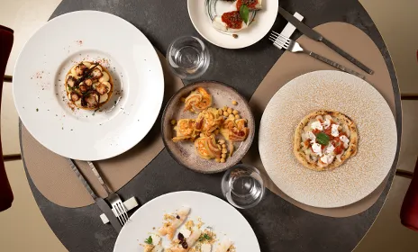 Tavolo imbandito con piatti di pesce del ristorante Da Sacerno a Bologna